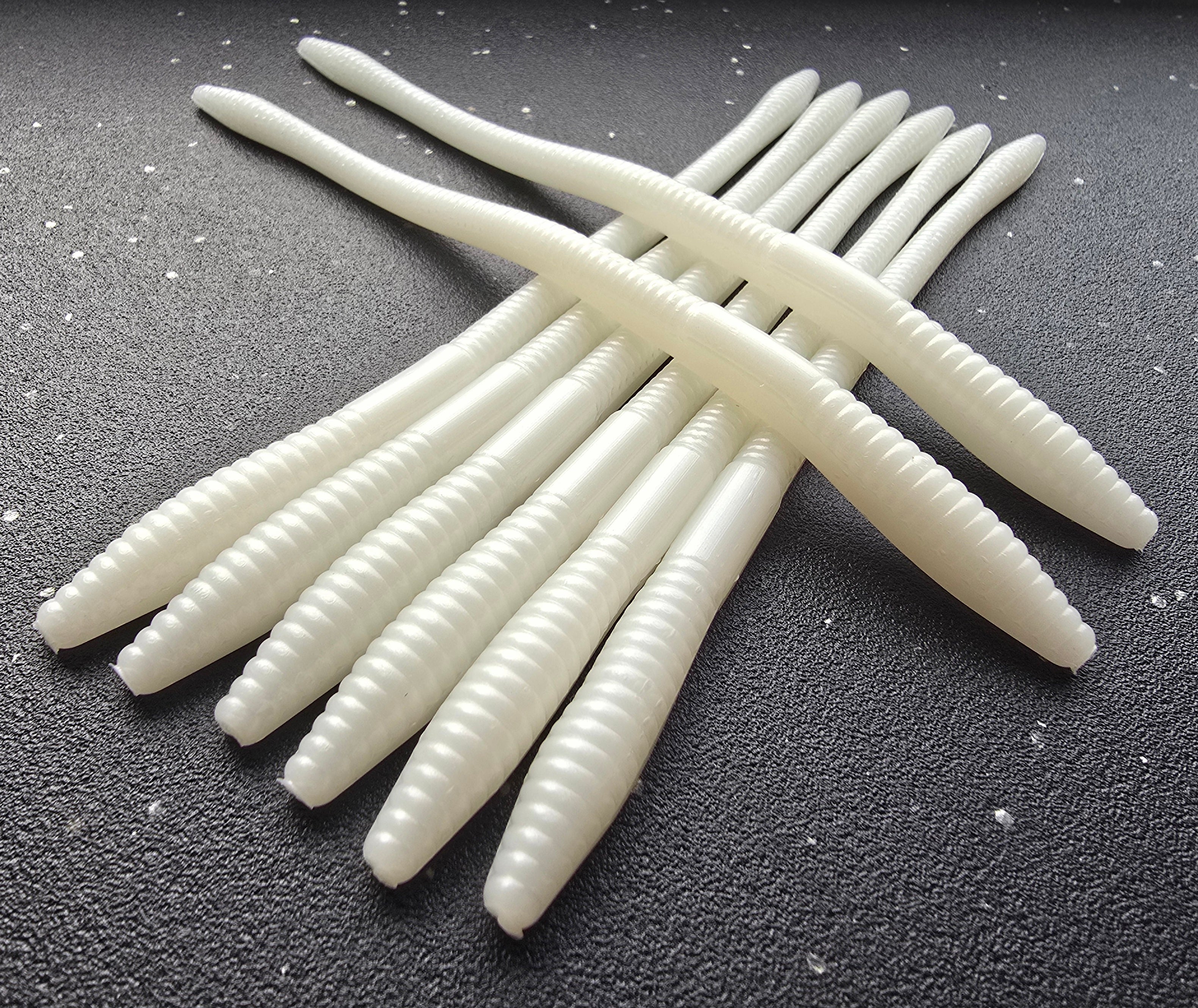 Eight Sapper baits Infiltrator Worms in Pearl White arranged in a cross pattern on a dark surface.