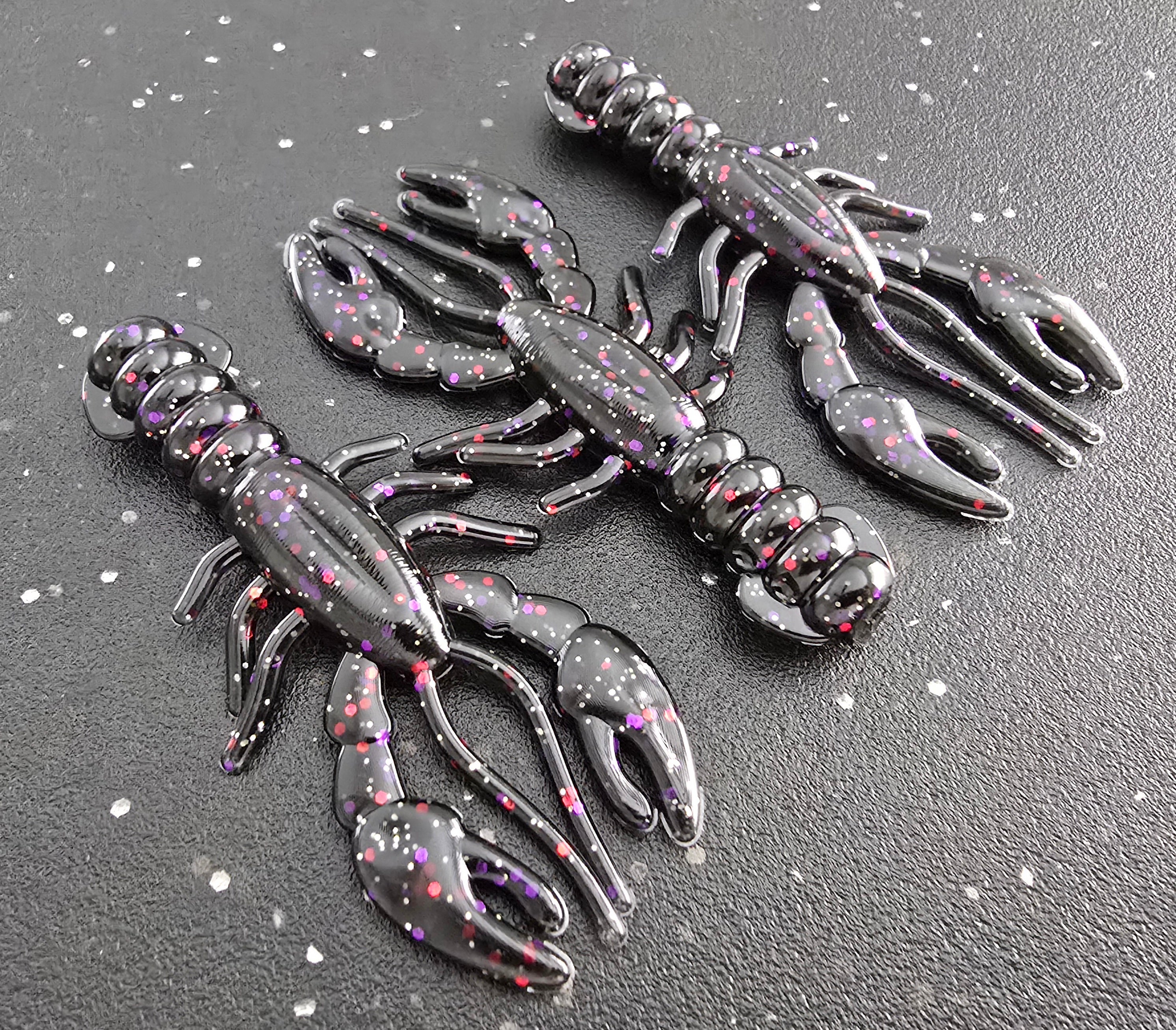 Three sapper baits breacher craw in black with red purple silver gold Flake